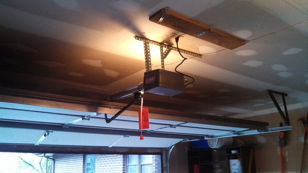 Garage door opener remote losing signal and range in Geneva IL: an installed garage door opener mounted to the ceiling