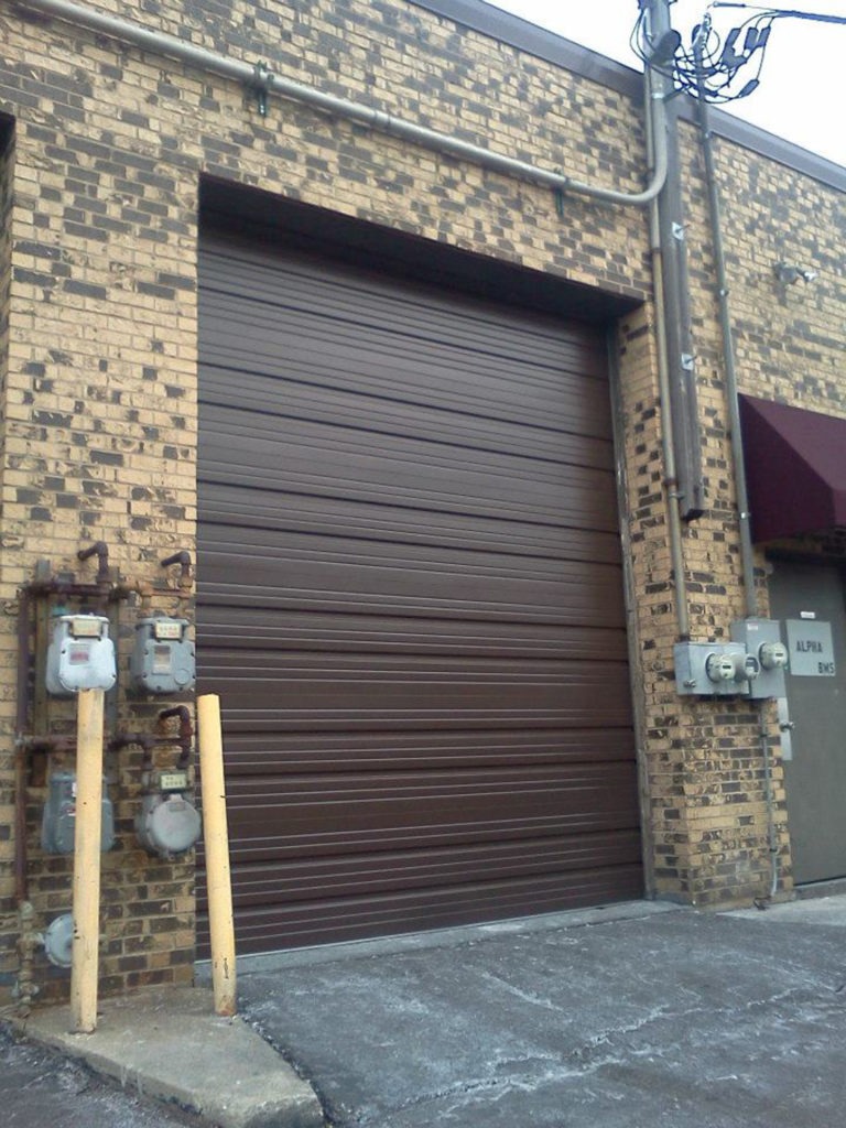 Garage door roller bracket cracked needing replacement in Wheaton IL: a brown sectional roller garage door installed