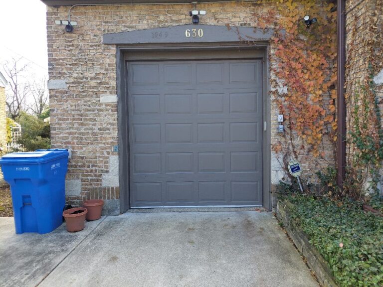 Garage door rollers worn out causing jerky movement in Lisle, IL: a dark gray residential garage door at 630 with brick