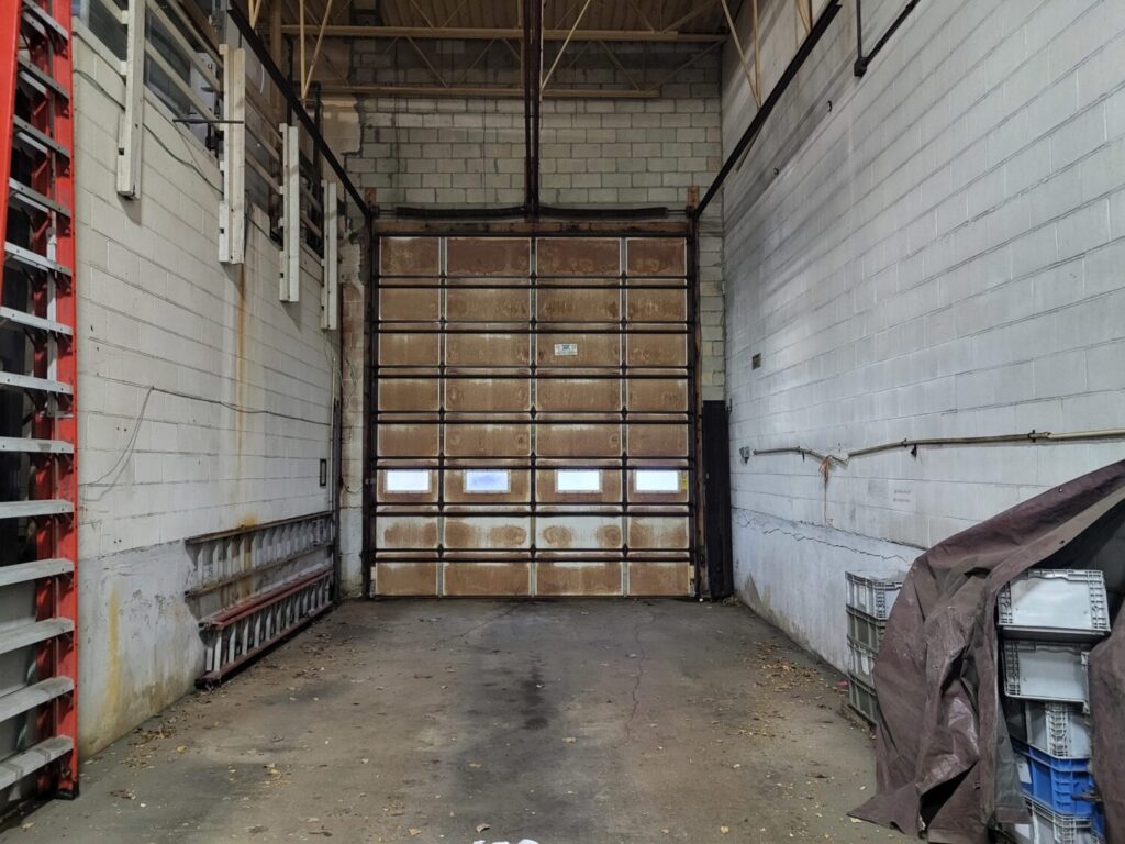 Garage door weather stripping cracked letting in cold air in Hinsdale, IL: interior view of an empty garage with a large